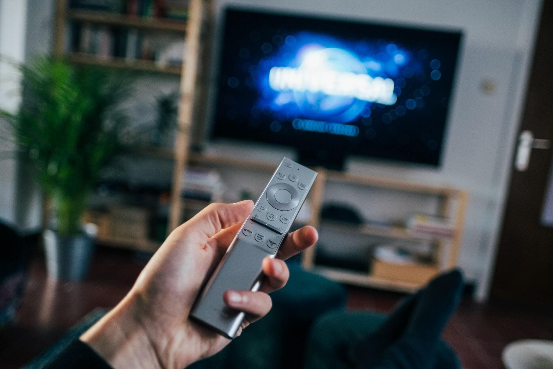 Picture of a TV in the background with a remote in the foreground